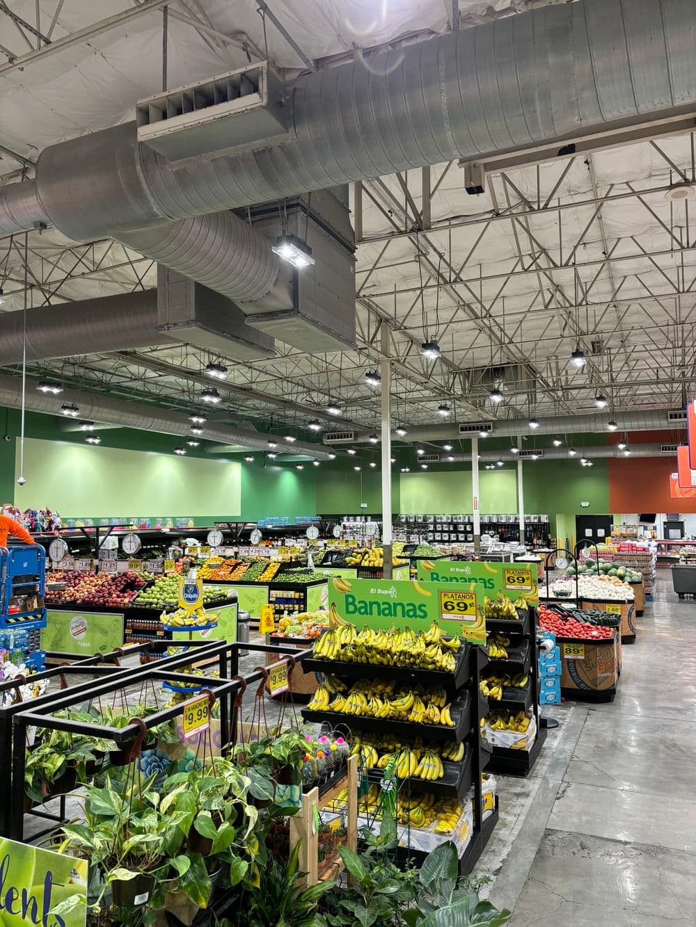 Grocery store interior with colorful produce displays, including bananas and various fruits.